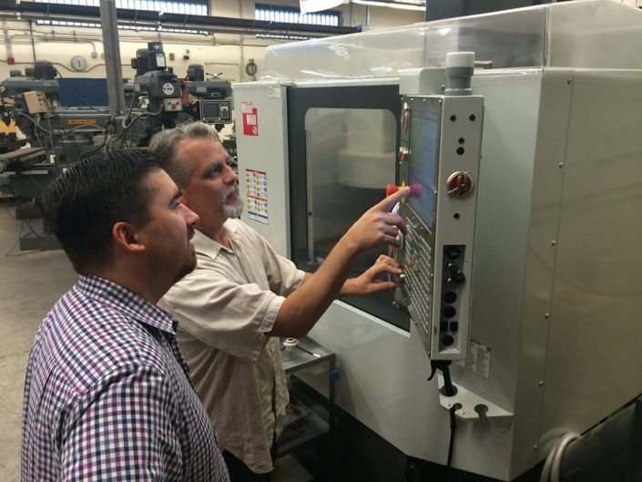 Greg Mercurio of SFA checking out a Haas CNC with a machine operator.