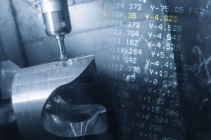 A close up of a machine's tool head at work cutting metal based on the data it receives from CNC manufacturing software, such as Predator DNC.