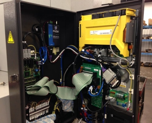 The door of a Fanuc CNC machine is opened to show that a Wi-fi Connect unit is mounted inside, adding a wireless DNC network.