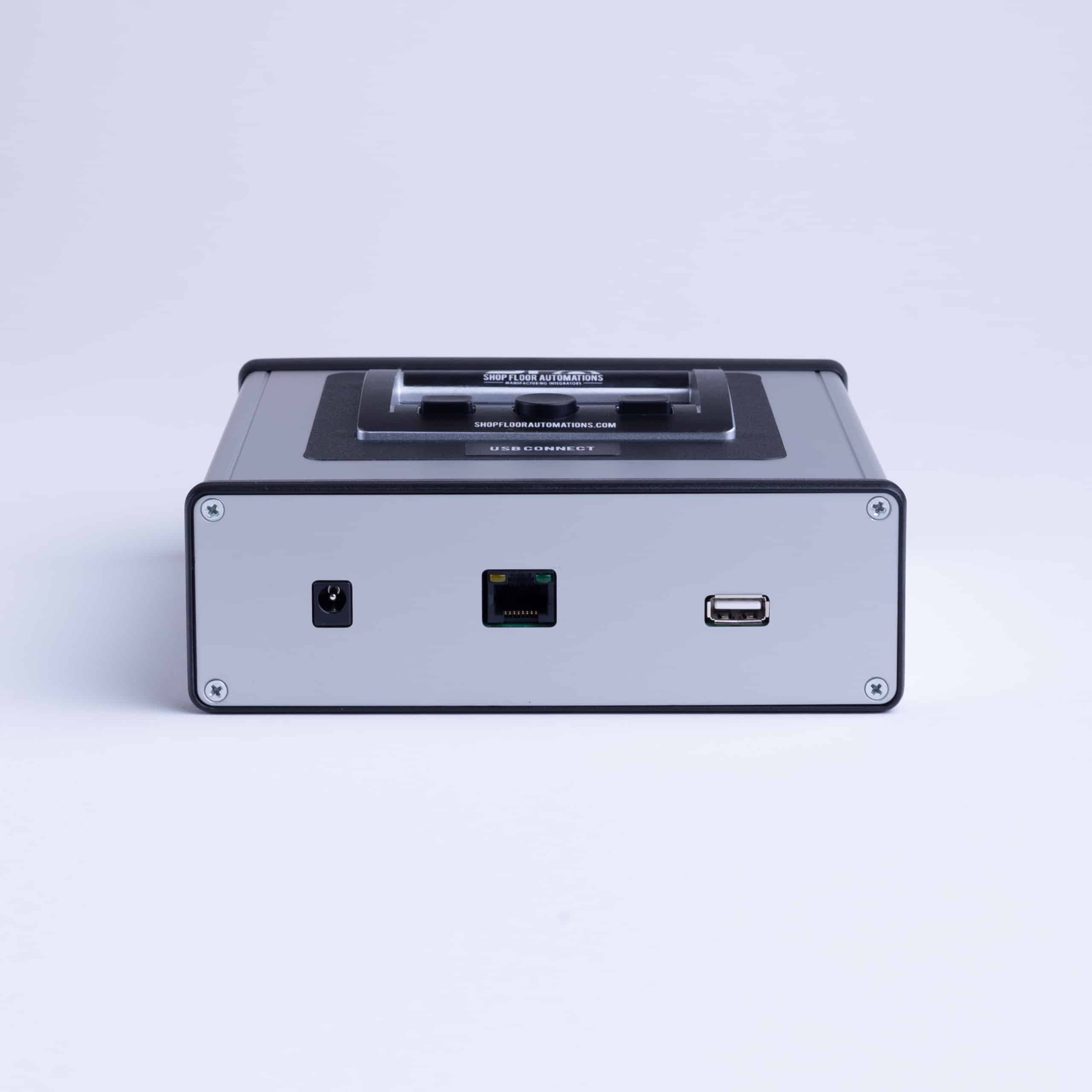 A bottom view of the USB Connect Portable, an external box-like DNC device, which shows its 3 ports: power supply port, serial port, and USB port.